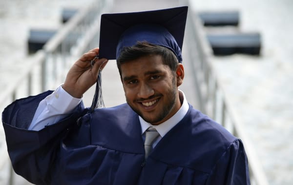 Graduating male student tipping his hat.